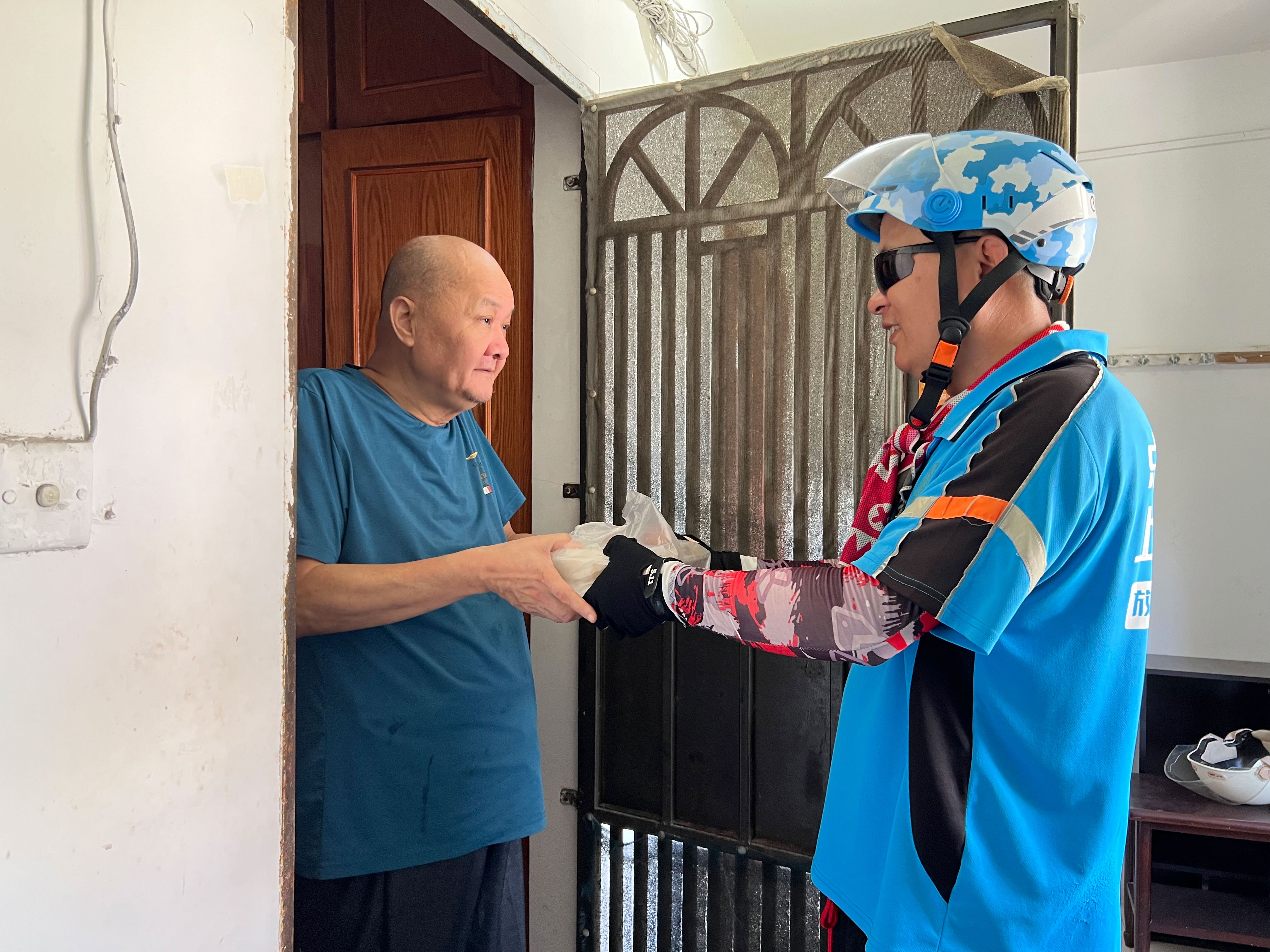 外卖小哥为老人送餐 陶悦清 摄